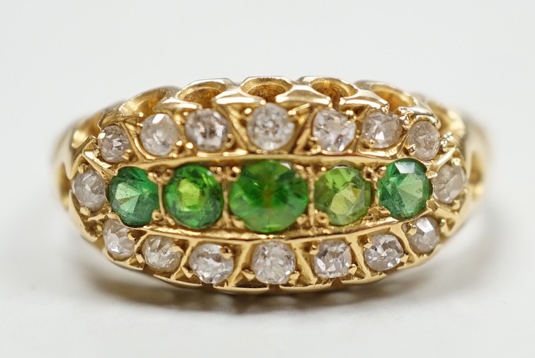 An Edwardian 18ct gold, demantoid garnet and diamond set oval cluster half hoop ring, size L, gross weight 3 grams.
